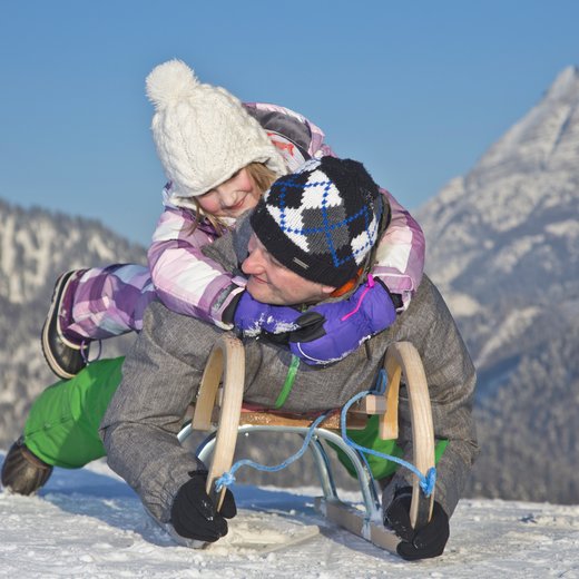 Vater mit Kind beim Rodeln | © defrancesco
