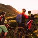 three friends are riding an e-bike withle sunset 