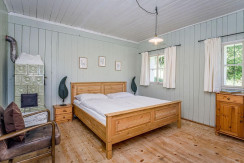 Zimmer mit Kachelofen und Holzbett